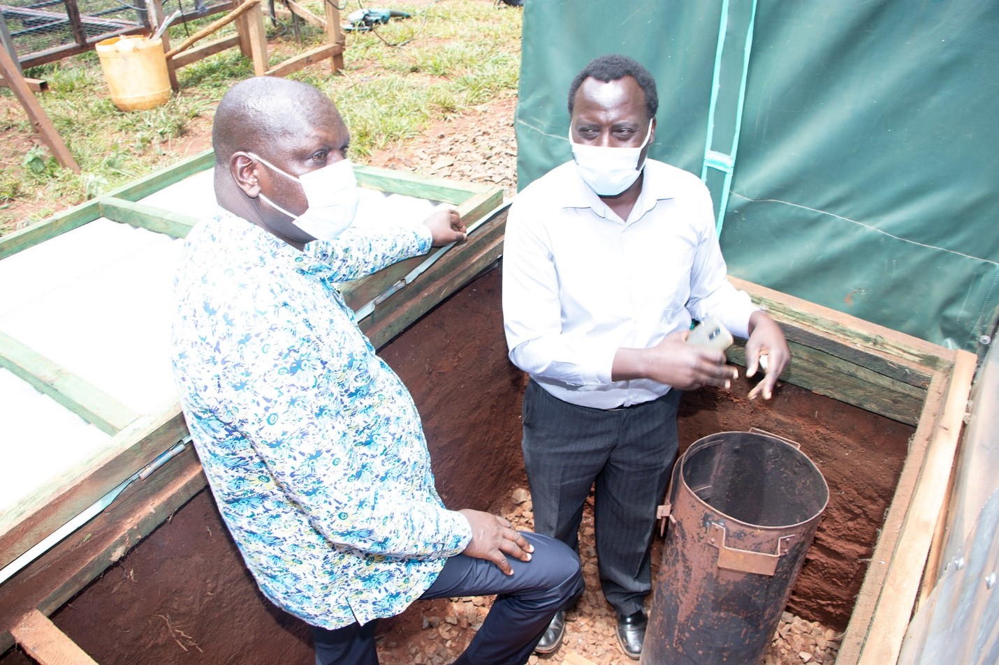 Dr. Muchilwa (innovator) explains to Prof. Kosgey (vice chancellor - Moi University) how the dryer works